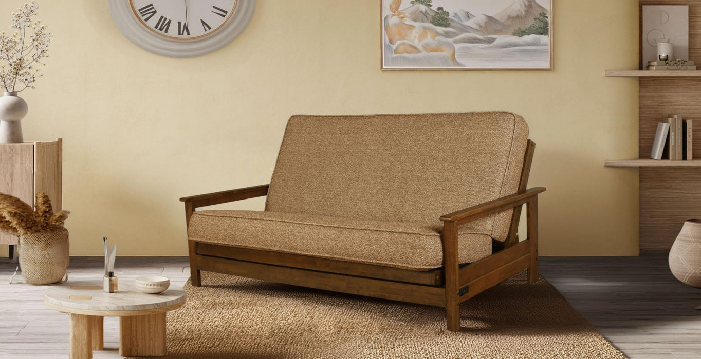 Wooden futon sofa in a living room with a clock, plant, and books on shelves.