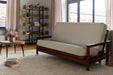 Beige futon sofa in a room with a bookshelf and coffee table.