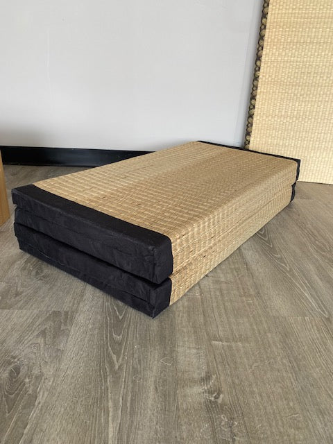 Folded rice straw mat on floor