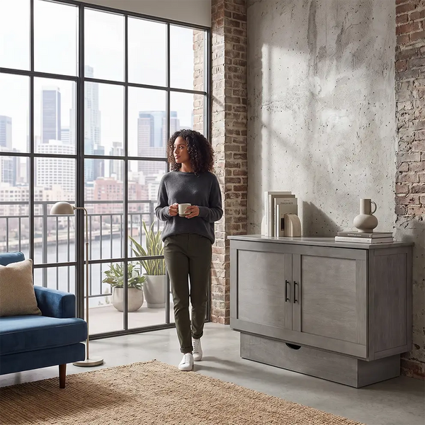 an upscale urban apartment with exposed brick walls. There is a beautiful credenza that turns into a bed. on along the wall. Also called a sleep chest or a cabinet bed.