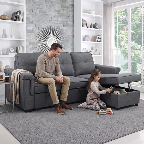 a stylish room showcasing a convertible sofa - a soft that turns into a bed. and has storage. A man sits on the couch watching his daughter play.