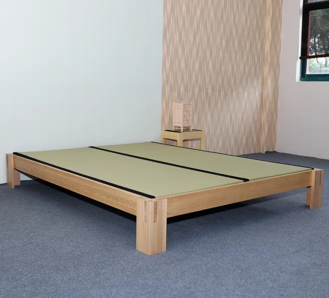 Low platform bed with wide corner legs and natural wood finish